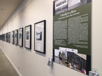 Image of framed images down a hallway as part of the "It Really is a River" exhibit at Central Library.